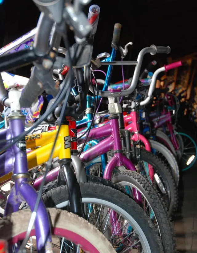 Reconditioned kids bikes lined up in the Community Bikes workshop