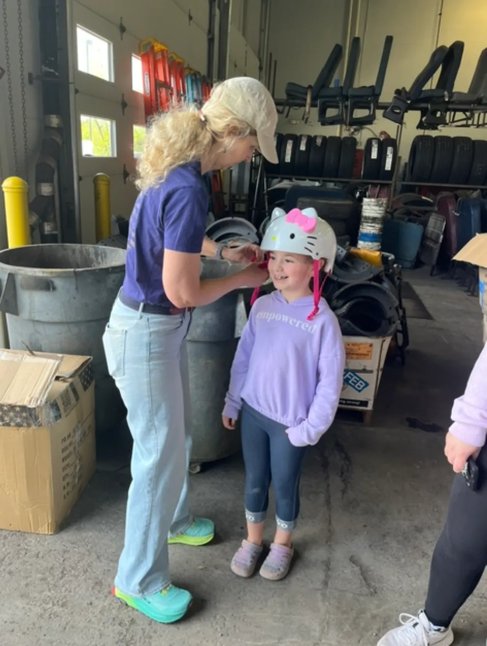 A volunteer fitting a helmet on a young girl