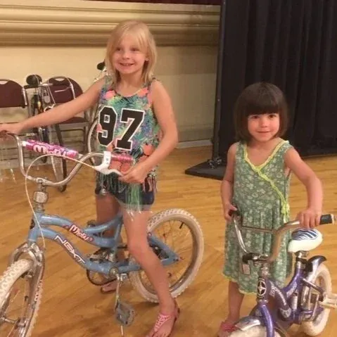 Two girls smiling with their new bikes