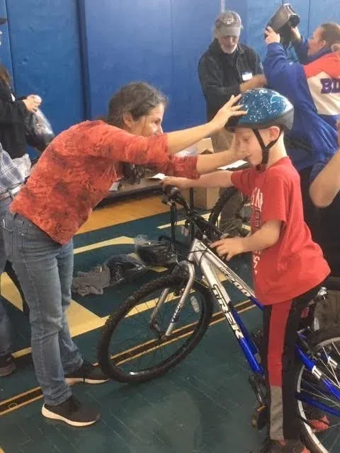 A volunteer checking a boy's helmet