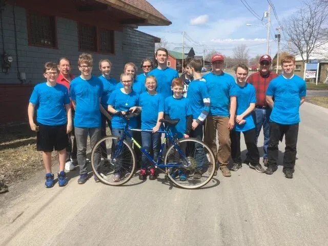 A volunteer group in matching blue shirts with bikes
